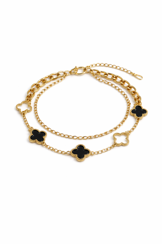 Gold bracelet with white and black clovers